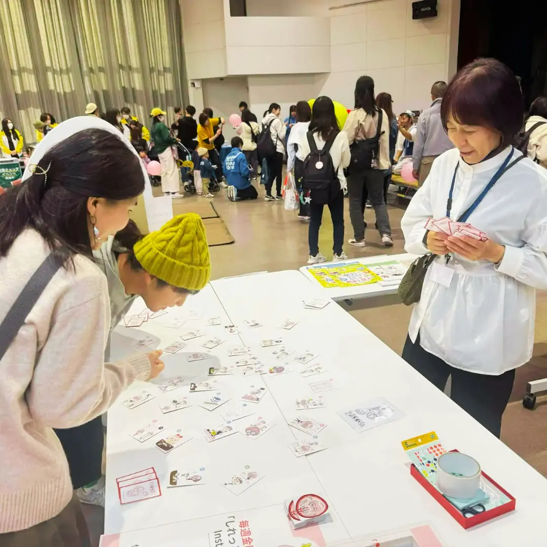 親子が展示テーブルのカルタを体験する様子